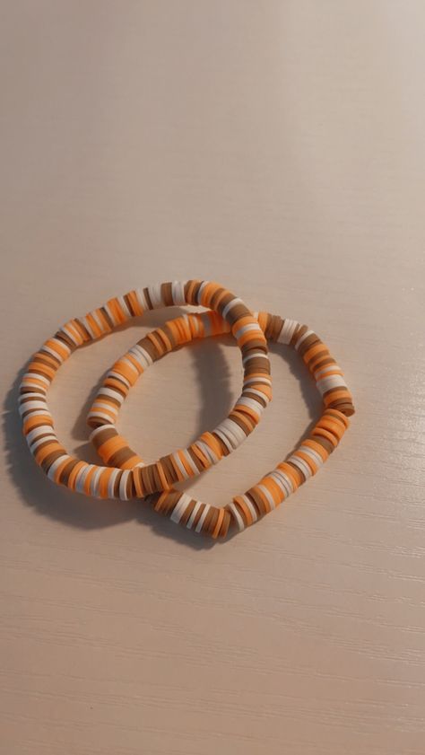 This is our Pumpkin Spice bracelet. If comes with two fall bracelets with the colors of white, brown, and orange. Fall Bracelet Colors Ideas, Fall Beaded Bracelets Ideas, Bracelet Idea Seed Beads, Preppy Fall Bracelet Ideas, Polymer Clay Bracelet Ideas Fall, Preppy Fall Clay Bead Bracelets, Clay Bead Bracelets Ideas Fall, Clay Bead Bracelet Ideas Fall Colors, Dark Friendship Bracelets