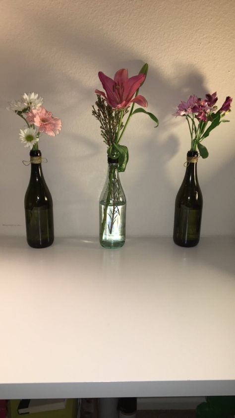 Wine bottle flower vase Glass Bottle Vase Decor, Wine Flower Centerpieces, Glass Bottle Flower Arrangements, Wine Bottles As Vases, Wine Vases With Flowers, Flowers In A Wine Bottle, Alcohol Bottle Flower Vase, Vine Bottle Decoration, Champagne Bottle With Flowers