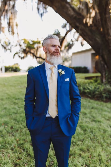 This bright royal blue suit and sun-kissed yellow tie are the perfect style combo for a classic Florida wedding. Navy Suit With Yellow Tie, Blue And Yellow Groomsmen Attire, Blue Suit Yellow Tie, Yellow Wedding Suit, Royal Blue Groomsmen, Royal Blue Wedding Suit, Suit With Yellow Tie, Blue And Yellow Suit, Men Blue Suit