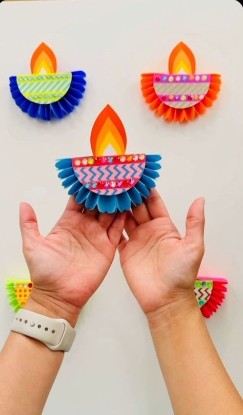 Add more color to your Diwali celebration with this lantern craft by iheartcrafts.ca. Before you start your next paper crafting session, pick up your supplies: your favorite colors of Astrobrights paper, colored string, and glue or tape. Pick up additional flair, such as stick-on gemstones, multicolored mini pom poms, and glitter to bring it all together. It’s perfect for Diwali decor in your home, office, or classroom. Get more craft inspiration at hte link. *Difficulty: Medium* Paper Lantern Craft, Diya Making, Diwali Craft For Children, Diwali Activities, Diya Decoration, School Board Decoration, Mini Pom, Lantern Craft, Diwali Decorations At Home