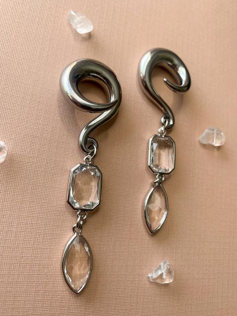 Silver Glass Jewel Dangles Hooks Lightweight Drop Dangle Earrings Gauges/Earplugs Plugs.Regarding sizing: Please be aware my hooks do run slightly smaller- much how single flares are a few decimal points smaller that double flares. Below are the sizes available along with the measurement of the hook at its largest part.6g - 3.7mm2g - 5.7mm0g - 7.7mm00g - 9.6mmThe details:-316 stainless steel spiral hook featuring silver tone plated glass charms.-All earrings are assembled by hand and sold in pai Cheap Handmade Elegant Plug Earrings, Earrings Gauges, Dangle Plugs, Ear Gauges Plugs, Ear Hangers, Plug Earrings, Glass Charms, Gauged Earrings, Ear Gauges