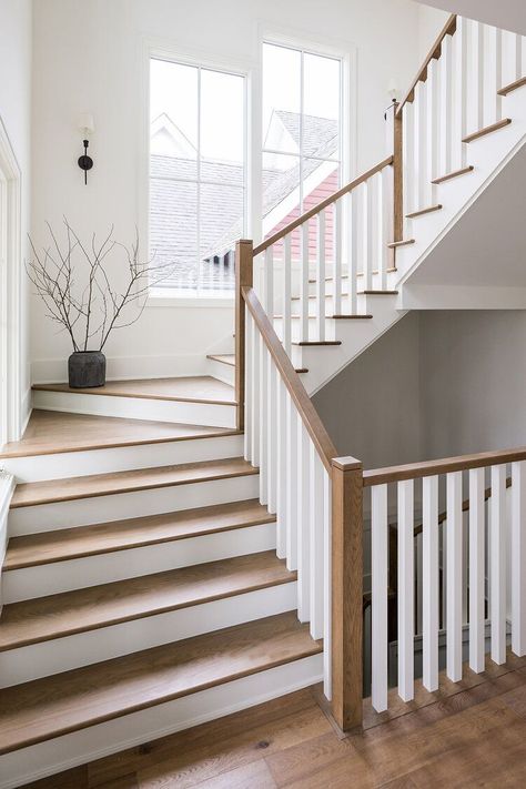 A gorgeous staircase is illuminated by large windows and rich wood. + staircase design + wood staircase + white spindles + grand staircase | Design By: aaNovo Wooden Staircase Design, Transitional Staircase, White Staircase, White Stairs, Staircase Railing Design, House Staircase, Wood Railing, Staircase Remodel, Wood Staircase