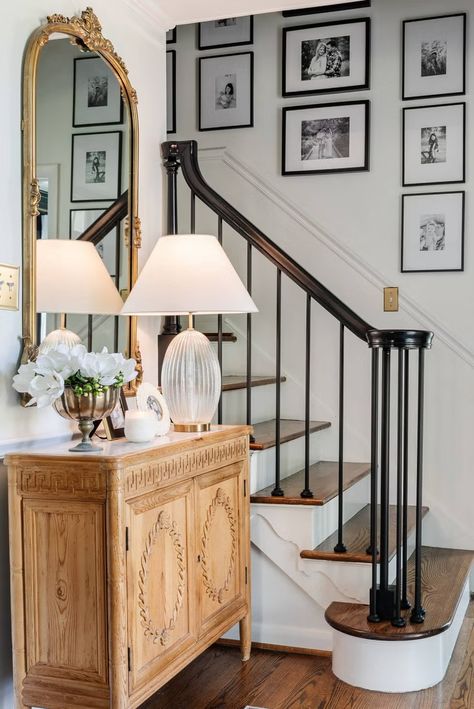 a staircase with a mirror and a lamp on the side Colonial Entryway, Black Stair Railing, Diy Stairs Makeover, Diy Staircase Makeover, تحت الدرج, Stairs Renovation, Stair Spindles, Black Stairs, Stair Makeover