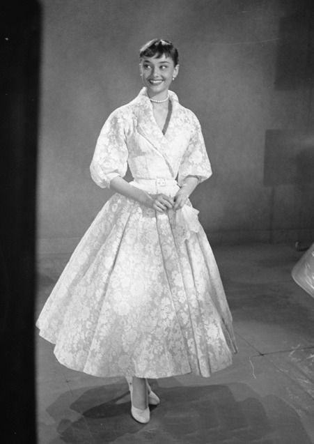 Remember this gown from Roman Holiday? At the 26th Annual Academy Awards, Audrey Hepburn wore a white floral, belted dress created by couturier Hubert de Givenchy.  The dress was  an adapted version of the gown designed by Edith Head for Roman Holiday. Audrey Hepburn Roman Holiday, Audrey Hepburn Dress, Audrey Hepburn Movies, Aubrey Hepburn, Dresses 50s, White Lace Midi Dress, Audrey Hepburn Style, Dress With Shawl, Vintage Dresses 50s