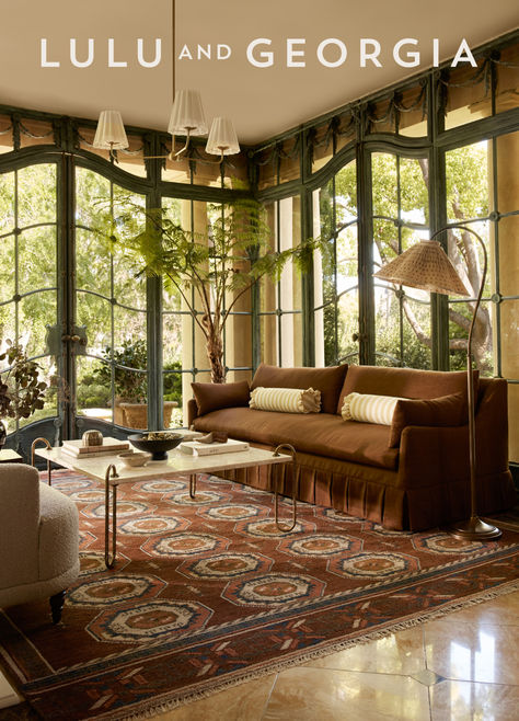 A brown sofa atop a traditional, vintage-inspired rug in a beautifully lit room surrounded by greenery outside Modern Cottagecore Living Room, Burled Wood Furniture, Luxe Furniture, Lulu And Georgia, Outdoor Furniture Collections, Outdoor Dining Furniture, Dining Room Bench, Long Hours, Furniture Dining Table