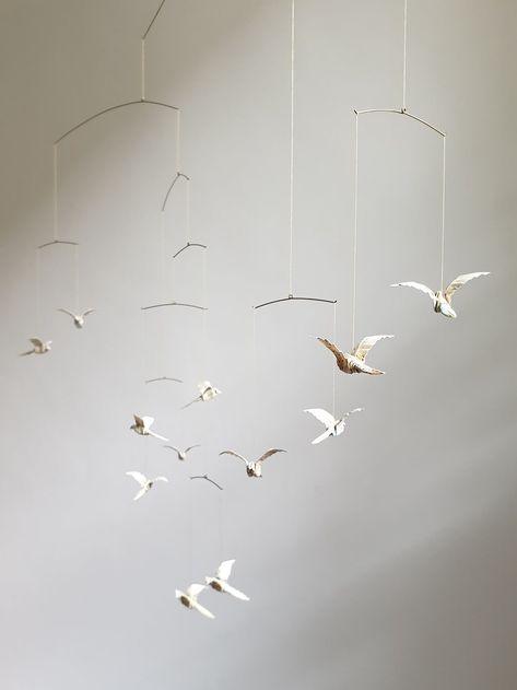 A delicate hanging mobile with white origami birds Ceiling Mobile Nursery, Hanging Paper Birds, Bird Hanging Decoration, Hanging Birds Decorations, Nursery Mobile Hanging From Ceiling, Origami Crane Mobile, Mobile Hanging Ideas, Origami Birds Hanging, Origami Mobile Diy