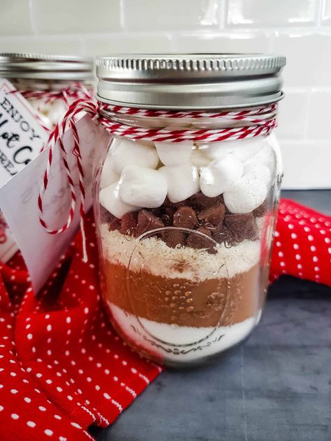 With just a few simple ingredients, you can create this easy-to-make homemade hot chocolate mix in a jar that your friends and family will love to receive. Mason Jar Hot Chocolate Gift, Hot Chocolate Jars Diy, Hot Chocolate Mason Jar Recipe, Hot Cocoa Jar Gift, Mason Jar Cocoa, Mason Jar Hot Cocoa Gift, Hot Chocolate In A Jar Recipe, Hot Chocolate Jars, Hot Cocoa In A Jar