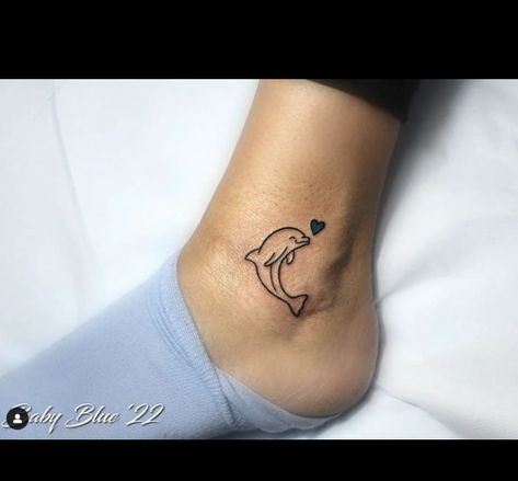 The dolphin tattoo represents love and peace, as shown by the blue heart in this tattoo. The dolphin is friendlier, and its bright smile and excellent performance are constant reminders of children laughing. It is a charming tattoo representing love,... Dolphin Wrist Tattoo, Small Dolphin Tattoo Designs, Dolphin Heart Tattoo, Dolphin Tattoo For Women, Small Dolphin Tattoo, Tattoos Dolphin, Tattoo Dolphin, Charming Tattoo, Memorial Tattoos Mom