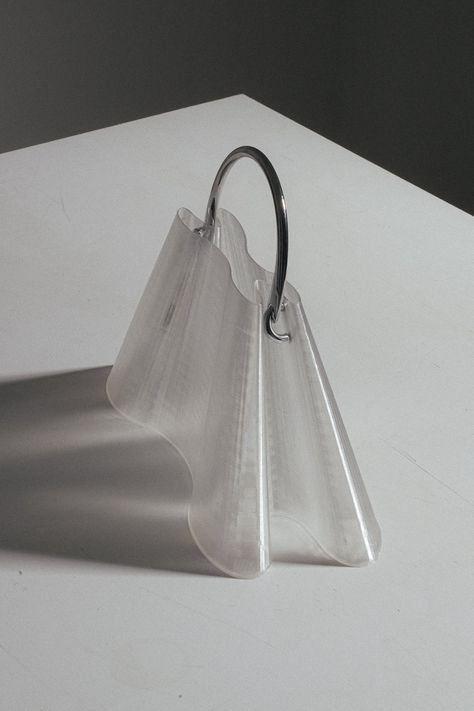 3D printed bag (or object), designed in collaboration with Argot, a Paris-based studio known by their organic shapes and architectural approach to objects. “Forme 1” purse is a mix between a soft-touch material and rigid metal handles. It fits all your essentials (phone, lipstick, card holder, keys). For more room, check “Forme 2” bag. Printing Time: 11 hours. Handles are individually assembled by hand. Colour: Transparent w silver metal handle. Arm fits through. Product size: 15cm height + 10cm 3d Printed Purse, Useful 3d Printed Objects, 3d Printed Bag, Fashion Objects, Metallic Aesthetic, Bag Shapes, 3d Printed Products, Miniature Ice Cream, Organic Bag