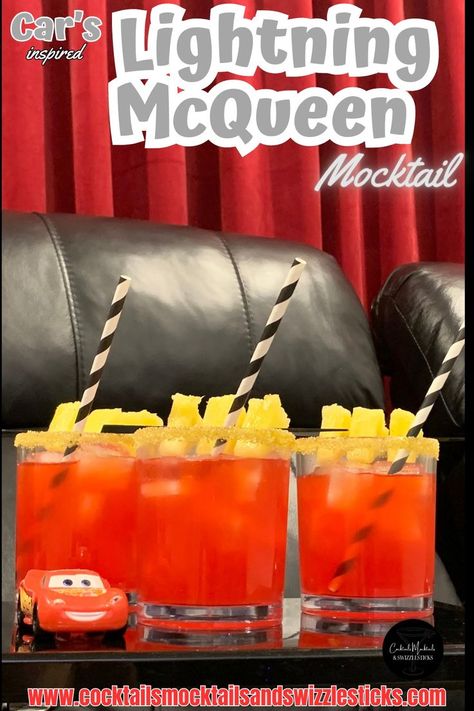 This image shows three red drinks with a yellow rim, pineapple garnish and black and white striped straws in a home movie theater with a Lightning Mcqueen car sitting next to them. Disney Themed Drinks, Disney Movie Night Menu, Disney Themed Movie Night, Disney Movie Night Food, Disney Movie Night Dinner, Movie Night Dinner, Movie Night Food, Disney Drinks, Disney Movie Night