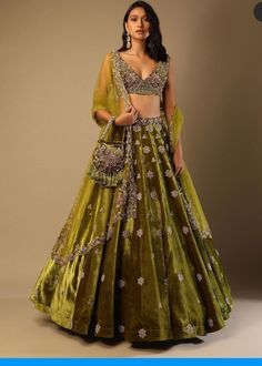 Lehenga Choli for Wedding Wear is stunningly embroidered in dabka, tilla, and sequins work on white raw silk choli paired with Raw Silk Green Lehenga and Net Pink Dupatta. ﻿A blossoming pink hue dupatta is paired up with a handcrafted mastery of pearls, zardosi, and sequins laid over an emerald green lehenga and a white choli in pure raw silk. Choli: Beautiful dress is gonna make your big day more beautiful in its design and styling having embroidered choli in without sleeves inc Green Lehenga Choli, Long Gown For Wedding, Velvet Lehenga, Simple Lehenga, Wedding Lehenga Designs, Kalki Fashion, Green Lehenga, Choli Designs, Embroidered Velvet