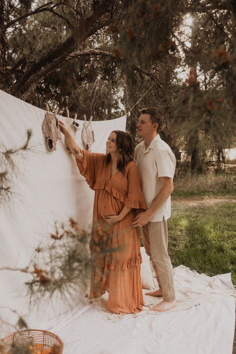 In the trees with a boho picnic. Gender Reveal Picnic For Two, Picnic Style Maternity Shoot, Maternity Photography White Sheet, Boho Maternity Pictures, Picnic Pregnancy Photoshoot, Boho Baby Announcement, Maternity Picnic Photoshoot, Clothes Line Maternity Pictures, White Sheet Maternity Shoot