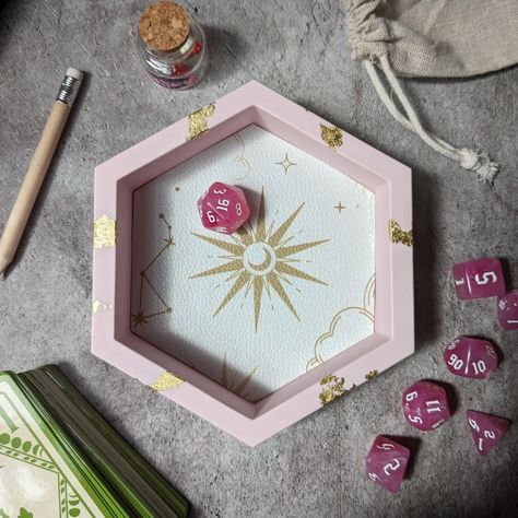 If you're looking to level up your dice rolling, swipe to take a look at some cute hexagon dice trays dropping tomorrow ✨ 24th June at 6pm ✨ All handmade from Jesmonite so they feel like stone and look amazing on your gaming table. ✨ Pink and gold celestial 🌌 Purple galaxy 🧚‍♀️ Iridescent fairy dragon scales 👻 Cute floral ghosty gals 🔮Pastel witch potions and pumpkins This is just the hex trays, a couple of other larger designs will be going live too for D&D, Pathfinder or whichever dice... D&d Dice Tray, Dice Decor, Dice Display, Witch Potions, Iridescent Fairy, Pastel Witch, Witch Potion, Purple Galaxy, Imaginary Friends