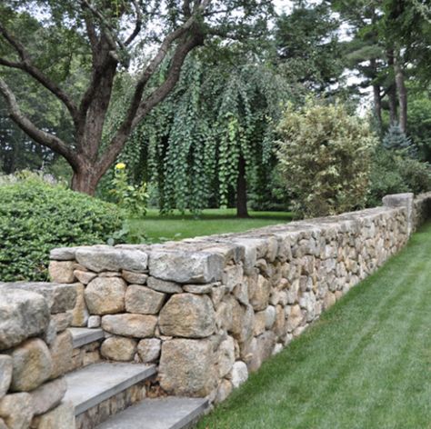 Large Land Landscaping, Front Yard Retaining Wall With Fence, Landscape Around Well Cap, Rock Wall Patio, Modern Stone Wall Outdoor, Natural Boulder Retaining Wall, Stone Wall Driveway Entrance, Alpine Garden Design, Retaining Wall Decorating Ideas