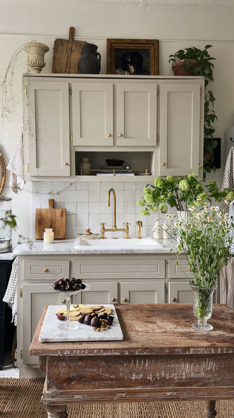 This magical NYC apartment kitchen setup uses brass details, reclaimed wood pieces, and an abundance of greenery to create a portal to the south of France. Check out our blog for more tips on how to navigate thrifting and antiquing! #apartmentdecor #kitcheninspo #livingspaces #thrifted #antique #cottagecore Parisian Farmhouse Kitchen, Neutral Vintage Kitchen, Thrifted Kitchen Island, European Apartment Kitchen, Vintage French Country Kitchen, English Country Decor Kitchen, South Of France Apartment, Thrift Kitchen Decor, 90s Kitchen Aesthetic