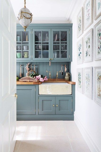 'Anyone can pick a paint colour, but getting the structure right is what makes a house', says Amanda Hornby, the interior designer who tranformed this Cotswolds dovecote into a family home. Amanda designed the cupboards in the kitchen, painted in Farrow & Ball's 'Card Room Green'. The green tone of the cupboards adds a fresh feel to the room, complimented by the green tones in the artwork on the gallery wall. Brass taps and fixtures give a feel of elegance to the simple style of the space. Railings Kitchen, Kitchen Paint Schemes, Casa Disney, Kitchen Cabinet Inspiration, Sophisticated Bathroom, Blue Kitchen Cabinets, Kabinet Dapur, Cabinets Ideas, Green Kitchen Cabinets