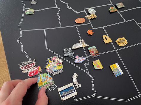 Introducing the Enamel Pin Collection Display Map - the perfect addition to any pin collector's showcase! This unique map is a large wrapped canvas with a striking black background and white ink outlines of each US state. It's a beautiful and stylish way to display your collection of enamel pins and showcase where you've collected them from. I hand draw these maps myself so if you would like to change the design or color or add names or a title to your map I am happy to do that! All orders with Travel Pins Display, Displaying Pins Collection, Travel Souvenirs Display Shelves, Map Display Ideas, Travel Pin Collection Display Ideas, Lapel Pin Display, Pin Collection Display Diy, Enamel Pin Display Ideas, Travel Souvenirs Display