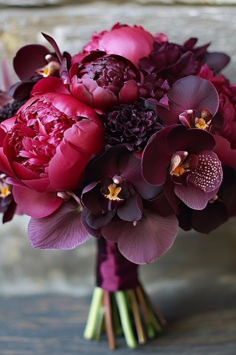 Deep plum orchids, rich wine-hued peonies, and sultry burgundy tones take center stage here. This purple wedding bouquet is for the bride who loves a bold statement with a sophisticated edge. Ready to turn heads with this dramatic beauty? Bring this luxe bouquet idea to life for your big day. Victorian Bridal Bouquet, Red And Purple Bouquet Wedding, Plum Color Flowers, Burgundy Wedding Inspiration, Burgundy Peony Bouquet, Purple Red Wedding Theme, Plum And Burgundy Wedding, Dark Purple Wedding Flowers, November Wedding Bouquet