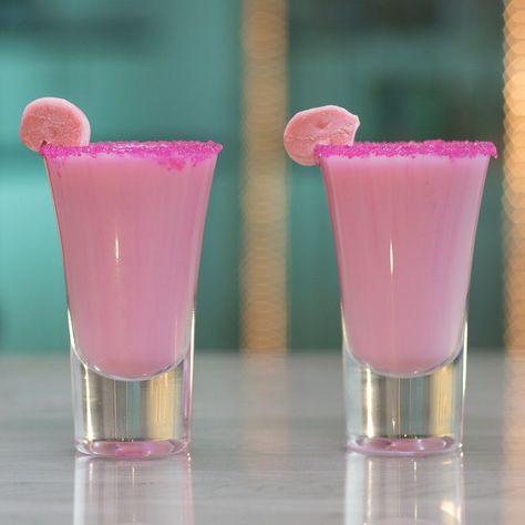 Blow your mind and some bubbles with this Coconut Bubble Gum Shot. This bright pink drink is made of bubble gum-infused rum, piña colada drink, and cream of coconut, and is garnished with pink sugar and a piece of bubble gum. Seriously though, this drink has Bazooka flavor. Pink Barbie Cocktails, Pink Shots Alcohol, Pink Shooters, Pink Pina Colada, Starburst Shots, Fun Drinks To Make, Pink Shots, Infused Rum, Girls Night Drinks