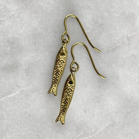 A fish symbolizes fertility, feelings, creativity, rebirth, good luck, transformation, health, abundance, serenity, intelligence, happiness, strength, and endurance. Connecting us with the water element, it represents the deeper awareness of the unconsciousness or higher self.  Gold plated solid 925 sterling silver or 925 sterling silver fish hook earrings. Fish measures 2cm in length. Material : Sterling Silver, 24k Gold Plate. Each piece is handmade to order in the Jewel Thief Brighton atelier Sardine Earrings, Gold Fish Jewelry, Pisces Earrings, Birthday 21st, Silversmithing Jewelry, Mothers Day Present, Birthday Gold, Fish Jewelry, Fish Hook Earrings