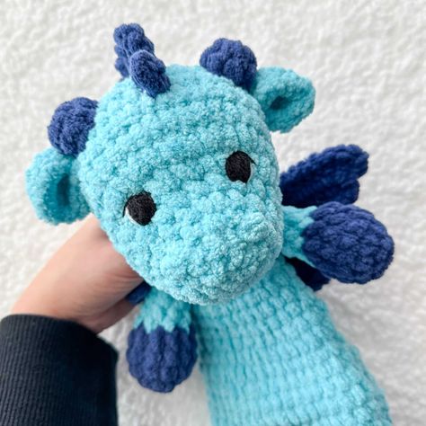 This is a free crochet snuggler pattern of a cuddly magical dragon! Half stuffed animal, half blanket but twice the fun! This crochet dragon lovey would be a great crocheted nursery gift! Embroidered eyes and blanket yarn make it more baby friendly. Crochet Snuggler Pattern, Snuggler Pattern, Crochet Snuggler, Dragon Half, Crochet Lovey Free Pattern, Magical Dragon, Crochet Dinosaur Patterns, Crochet Dragon Pattern, Crochet Baby Gifts