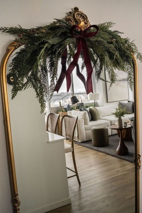 Anthropologie Mirror Christmas Decor, Mirror Swag Garlands, Gold Mirror Christmas Decor, Mirror With Garland Christmas Decor, Swag For Mirror, Christmas Decor Greenery, Pine Swags Christmas, Christmas Garland For Mirror, Christmas Garland Mirror Decor