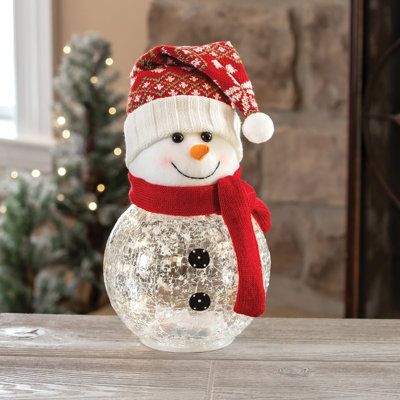 Brighten your holiday with this plush and crackle glass snowman. Includes 10 starry lights. Studio 66 | Studio 66 Frosty Top Lighting 7.2 H x 7.2 W x 9.96 D in brown / red / whiteGlass / Mercury Glass | 7.2" H X 7.2" W X 9.96" D | Wayfair Vase Snowman, Snowman Mason Jar, Lighted Snowman, Allergy Medicine, Starry Lights, Glass Snowman, Snowman Christmas Decorations, Christmas Glasses, Blue Christmas Tree