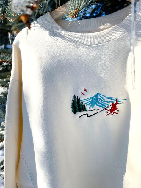 We sell primarily on our website where we offer faster turnaround and free shipping options.  TwinRavenCo Heavyweight Vintage Ski Scene Crewneck. 𓄿 Embroidered in our studio in Canada with sustainable threads 𓄿 Unisex- recommend to size down one size, please see size chart  𓄿 Reverse cover stitch sewing on all seams for durability and a premium finish 𓄿 Twill neck tape 𓄿 1 x 1 ribbing at neck, cuffs and waistband 𓄿 Double ribbing side panels for stretch 9oz 80% Cotton/20% Polyester 100% Cotton Face, 30 Singles * Check out our socials for discounts, new releases, and to see how we run our shop: TwinRavenCo Embroidery stabilizer is applied to the back of every embroidered item and is never to be removed. It is there to keep the stitches stable over time. This stabilizer naturally softe Ski The East, Apres Ski Outfits, Sweater Embroidery, Stitch Sewing, Retro Ski, Embroidery Sweater, Ski Sweater, Vintage Ski, Embroidered Sweater