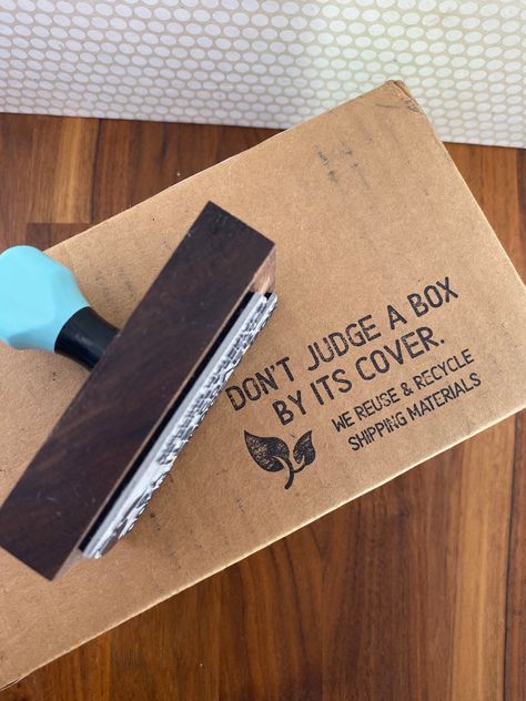 "Save the planet one box at a time. Many small businesses can make a huge impact when they reuse boxes for shipping new orders. Use this stamp to imprint your box and let your recipient know they have taken a part in helping Mother Earth. This is for a stamp: \"Don't Judge a Box By It's Cover\" We Reuse and Recycle Shipping Materials There is a leaf to the left. If Logo is selected your logo will take that place of the leaf. If you are looking for an address stamp or a custom image stamp there a Custom Stamp Logo, Rubber Stamps Diy, Packaging Stamps, Eco Friendly Business Cards, Teacher Stamps, Price Of Stamps, Business Stamps, Reuse And Recycle, Recycle Box