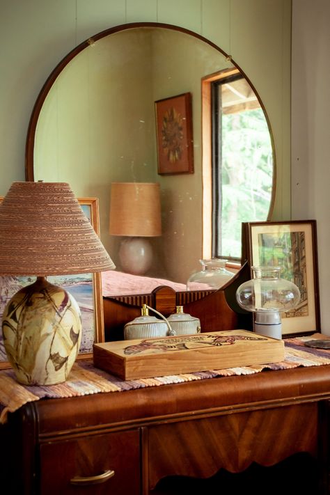 David and Mitzi spend their summers on Shuswap Lake. They have a knack for thrifting and developed a love of ’60s/’70s interiors. This home appeals to their love of nature, people, food, animals, and art. Dresser With Round Mirror, Bedroom 60s, Thrifted Bedroom, 60s Interior Design, 70s Bedroom, 60s Interior, 60s Decor, Art Deco Wood, 70s Interior