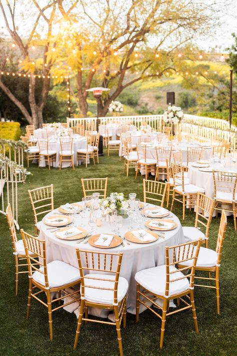 Gold chiavari chairs, herb napkin treatments, gray linen with gold chargers and gold floral vases/towers with white & green florals helped create our "south of France" vibe. #africanwedding #ghanaianwedding #englishwedding #multiculturalwedding #losangelesweddingplanner #goldwhitegray #goldchiavarichairs #stringlights #goldchargers #graylinen #delmarevents #Kellogghouse #munaluchibride Chiavari Chairs Wedding, Casa Romantica Wedding, Hummingbird Nest Ranch Wedding, Wedding Reception Chairs, Ghanaian Wedding, Hummingbird Nest Ranch, Gold Chiavari Chairs, Hummingbird Nest, Reception Tables