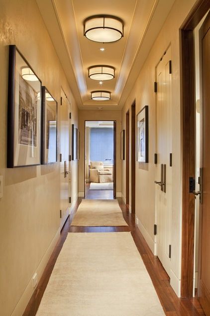 A great way to address lighting in a hallway with a low ceiling is to create repetition using a flush-mounted ceiling light. This repetitive pattern can create interest and drama when you don't have the space for a larger fixture. Bright Hallway, Lighting Hallway, Hallway Ceiling, Blitz Design, Low Ceiling Lighting, Hallway Light Fixtures, Hall Lighting, Upstairs Hallway, Hallway Designs