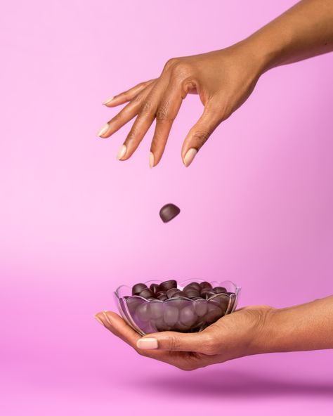 A ladies hand dropping a gummy vitamin into a glass bowl of more gummy vitamins. Pink background. Vitamin Gummies Photography, Gummies Product Photography, Gummy Vitamins Aesthetic, Gummy Product Photography, Gummy Photography, Wellness Product Photography, Gummies Photoshoot, Supplement Product Photography, Gummy Photoshoot