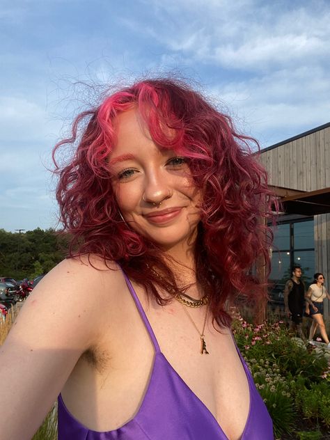 pink hair, curls, pink curls, red hair, red curls, pink bangs, pink money piece, short hair, hair color, fun color, purple dress, satin dress, gold jewelry, nose ring, septum, glowy makeup, simple makeup, pink eyebrows red hair, pink hair, hair inspo, pink bangs, pink eyebrows, gold jewelry, gold nose ring, gold septum ring, summer hair Dark Hair Pink Money Piece, Pink Streaks In Red Hair, Pink Hair With Money Piece, Pink Hair Money Piece, Red Hair With Pink Money Piece, Burgundy Money Piece Hair, Pinky Red Hair, Pink Wavy Hair, Pink And Burgundy Hair