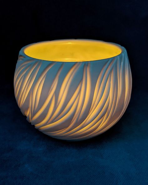 Made on the wheel and hand-carved porcelain. Translucent all the way through, especially where the porcelain is thinnest.  By daylight it's white and blue-green and warm glow by candle.  #pottery #porcelain #handmade #homedecor #luminary #ambiance #candlelight #tealight #ceramics Luminary Clay Ideas, Ceramic Illuminaries, Ceramic Votive Candle Holders, Porcelain Luminaries, Luminary Pottery, Clay Luminaries, Space Pottery, Candle Pottery, Carved Porcelain