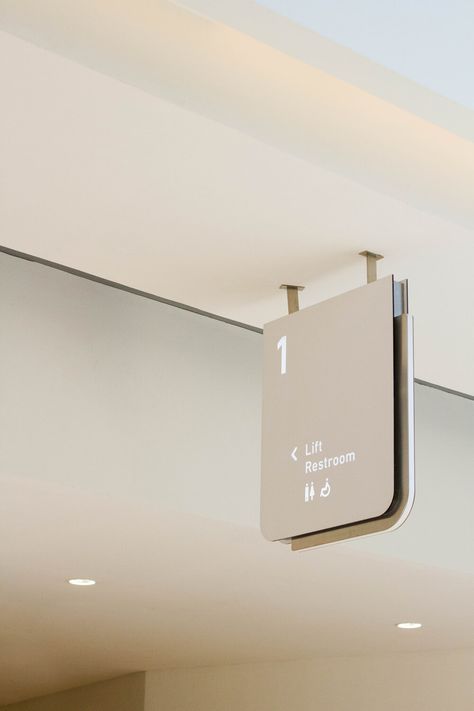 Amenity signage in matte white acrylic, featuring a brushed steel outline. Hospital Signage Design, Room Signage Design, Signage System Design, Interior Signage Design, Minimalist Signage, Office Signage Design, White Signage, Hospital Signage, Interior Signage