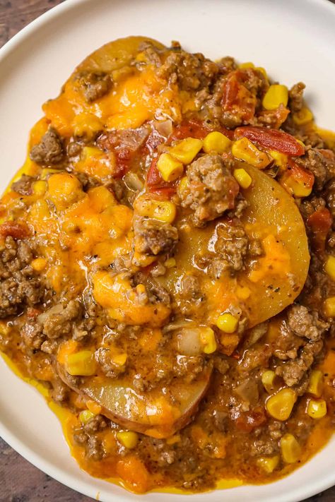 Crock Pot Cowboy Casserole is a hearty slow cooker dinner recipe loaded with ground beef, diced tomatoes, potatoes, corn and cheese. Slow Cooker Lumberjack Casserole, Recipes With Ground Beef In Crock Pot, Slow Cooker Hobo Dinner, Crock Pot Inspired Recipes Ground Beef, Cowboy Supper Crock Pot, Slow Cooker Cowboy Supper, Ground Beef Sweet Potato Crockpot Recipes, Easy Slow Cooker Stew Recipes, Beef And Potatoes Recipes Slow Cooker