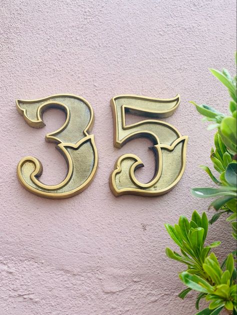 Number 35 brass house numbers on exterior house wall. Victorian Typography, Brass House Numbers, Front Door Numbers, Unique Front Doors, Brass Door Knocker, Front Door Entrance, Door Numbers, House Number Sign, Address Signs