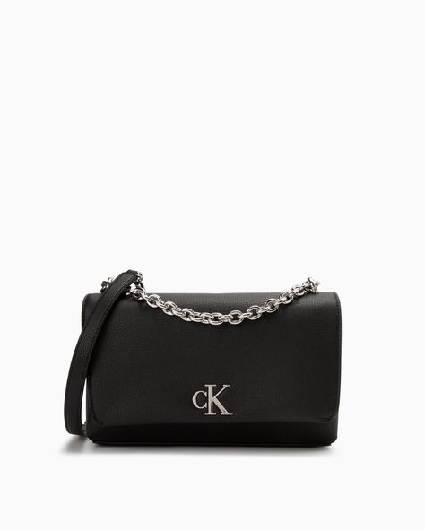 Details The compact shape of this crossbody bag from Calvin Klein Jeans is stamped with a cK Monogram metal applique and a metal chain strap. It provides easy access to your essentials. • Top flap with magnetic closure • Main compartment with interior card slot • Back slip pocket • Adjustable shoulder strap with metal chain • Polished cK Monogram applique on the front • 25x7x16 cm Style #: DH3440-001001 Calvin Klein Crossbody Bag, Calvin Klein Crossbody Shoulder Bag, Luxury Calvin Klein Crossbody Bag, Modern Calvin Klein Black Bag, Chic Calvin Klein Bags For On-the-go, Calvin Klein Bag, Jean Accessories, Womenswear Fashion, Pretty Bags