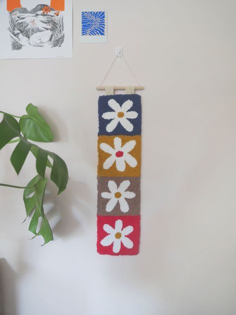 Handmade punch-needle wall hanging Cute decorative wall hanging with a patchwork flower design, hand crafted by me! Made with 100% cotton wool, features dowel and string to hang up and felt backing. Perfect for decorating your home, or as a gift, whilst shopping small! Each item is handmade and unique so they may vary from product photos. Dimensions: approx 14cm x 51cm/5.5in x 20in Please note these are handmade items so please look after them. If you have any questions please do not hesitate to Punch Needle Hanging, Punch Needle Wall Art Ideas, Punchneedle Wall Art, Framed Punch Needle Art, Boho Punch Needle, Large Punch Needle Wall Hanging, Botanical Punch Needle, Punch Needle Wall Art, Punch Wall