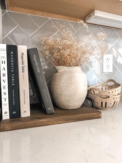 Kitchen Counter Cookbook Display, Marble Countertops Kitchen Decor, Kitchen Counter Styling Apartment, Display Cookbooks, Magnolia Table Kitchen Decor, Kitchen Stove Decor Ideas, Simple Island Decor, Decorating With Cookbooks, Long Countertop Decor