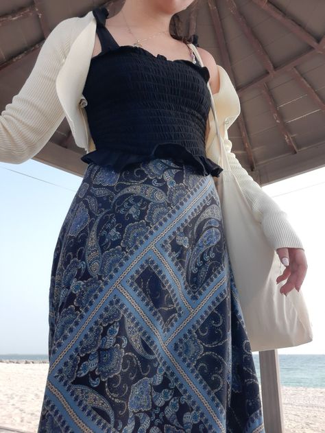 A beachy outfit with a black top, a printed blue skirt, white jacket, and tote bag Windy Beach Outfit, Outfits For Windy Days, Beach Fits, Beach Outfits, Windy Day, Pool Days, Day Outfit, Cold Day, Beach Day