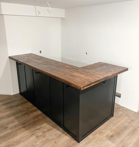 L-shaped bar for this newly renovated basement! 🖤 finished in a tricorn black base and Dark Walnut stain on a wooden oak top. 

Keywords: L Shaped Bar, Bar Unit, Basement Bar, Basement Ideas, Basement Inspiration, Basement Inspiration, Downstairs Bar Unit, Downstairs Bar, Custom Bar Unit, Custom Bar, Custom Furniture, Custom Woodworking, Wood Bar. Basement Bar Remodel Before And After, Basement Bar Setup, L Shaped Bars Basement, Cheap Basement Bar Ideas, Basement Bar Top Ideas, L Shaped Dry Bar, Basement Bar Area Ideas, Diy Bar In Basement, Small Bar Basement Ideas