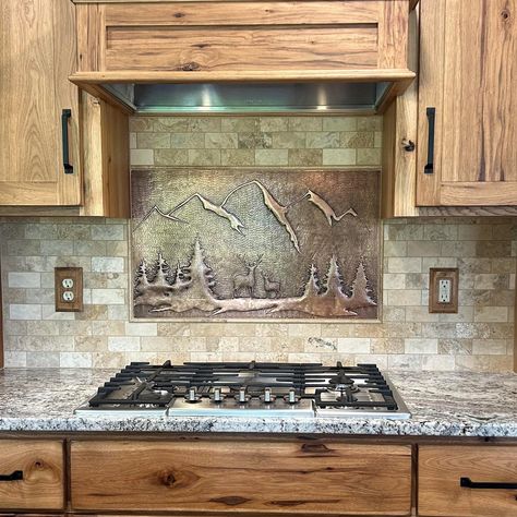 Create a unique and rustic kitchen with our forest scene artwork backsplash. Handmade with real copper, this backsplash pairs perfectly with wood cabinets, adding a touch of nature to your kitchen. Transform your space with our one-of-a-kind design, featuring a serene forest, deer, and stunning mountains and trees. The best kitchen backsplash idea for any nature lover. Backsplash Country Kitchen, Kitchen Backsplash Ideas With Knotty Alder Cabinets, Counter Tops And Backsplash Ideas, Rustic Backsplash Kitchen, Oven Backsplash Ideas, Kitchen Backsplash With Wood Cabinets, Cabin Backsplash, Rustic Kitchen Backsplash Ideas, Wood Backsplash Kitchen