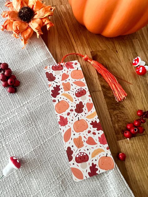 Autumn Leaves Bookmark, perfect for those cosy autumn evenings tuck up with a book! These cute bookmarks are printed on quality 400gsm cardstock, with a smooth Matt lamination. Details: - 148mm x 52mm - Rounded corners - Choice of with or without burnt orange tassel - Double sided print: back side has the mochiimakes logo on it - Smooth Matt Laminated Bookmark - Printed on high quality 400gsm Cardstock All bookmarks are shipped in board backed envelopes for extra protection. Orange Bookmark, Cottagecore Halloween, Fall Bookmarks, Autumn Bookmark, Leaf Bookmark, Book Tabs, Bookmark Printing, Creative Bookmarks, Watercolor Bookmarks