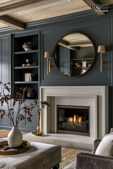 Elegant dark-themed fireplace with dark paneling, a white fireplace surround, a chic round mirror, and refined decor elements. Living Room With Brass Accents, Dark Living Room Fireplace, Decorative Fireplace Wall Ideas, Contrasting Fireplace Wall, Millwork Above Fireplace, Fire Place Mirror, Traditional Timeless Living Room, Transitional Fireplace Ideas With Tv, Fireplace Panelling Ideas