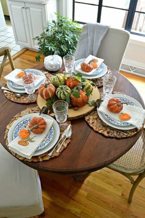 small round dining table set simply for fall with orange pumpkins and blue and white dishes for a Simple Fall Tablescape Ideas post Round Table Settings, Thanksgiving Dining Table, Fall Dining Table Decor, Small Round Dining Table, Thanksgiving Dining, Fall Dining Table, Round Table Decor, Autumn Dining, Round Dining Table Sets