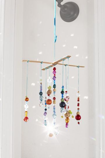 Hang this mobile in a light-filled window to really let it glimmer and glow. Just be sure to keep it out of reach of little kids; the beads are a choking hazard. Ocean Mobile Craft, Preschool Mobile Ideas, Kids Wind Chime Craft, Kids Mobile Craft, Hanging Mobiles Ideas, Wind Chimes Craft For Kids, Hanging Crafts For Kids, Wind Chimes For Kids, Diy Mobiles