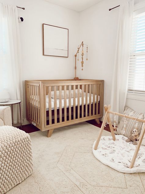 Neutral minimalist baby nursery. Ivory and white. Neutral baby playmat. Light wood baby crib. Brass baby mobile Gender Neutral Nursery Dark Wood Floor, Mid Century Modern Gender Neutral Nursery, White And Wood Nursery Ideas, Small Minimalist Nursery, Nursery With Natural Wood Crib, Light Wood Nursery Furniture, White And Brown Nursery, Minimalist Nursery Ideas Gender Neutral, White And Beige Nursery