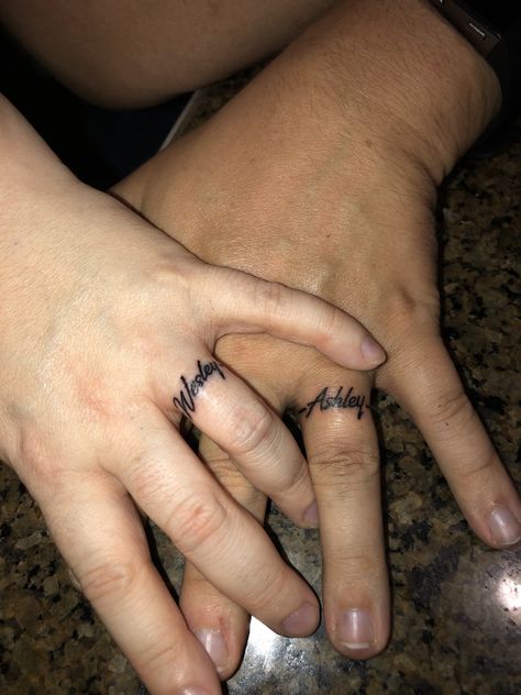 Tattoos Of Names Boyfriends, Tattoo On Ring Finger Name, Hubby Tattoo Ideas, Wedding Ring Finger Tattoos Initials, Wedding Band Tattoo Ideas For Couples, Name Tattoos Finger, Name Ring Tattoo, Husband Name Tattoo Ideas, Boyfriend Name Tattoo Ideas For Women